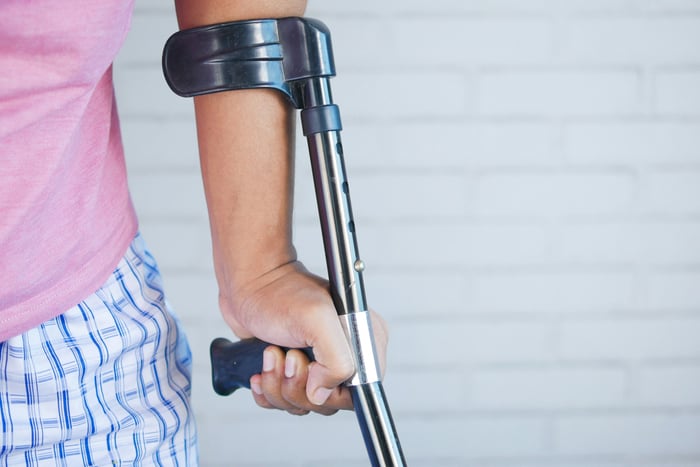 A person holding a crutch